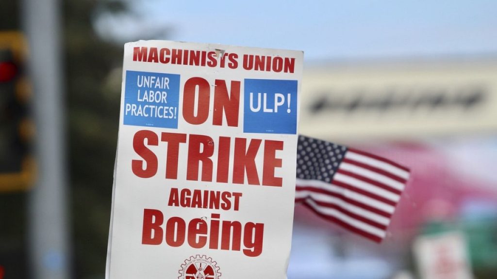 A strike sign is waved on the union machinist picket line near Boeing