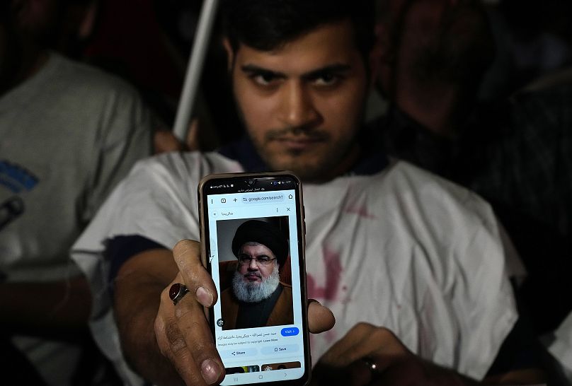 Un manifestant iranien montre un portrait du chef du Hezbollah Hassan Nasrallah sur son téléphone lors d'une manifestation de soutien au Hezbollah à Téhéran, le 28 septembre 2024.