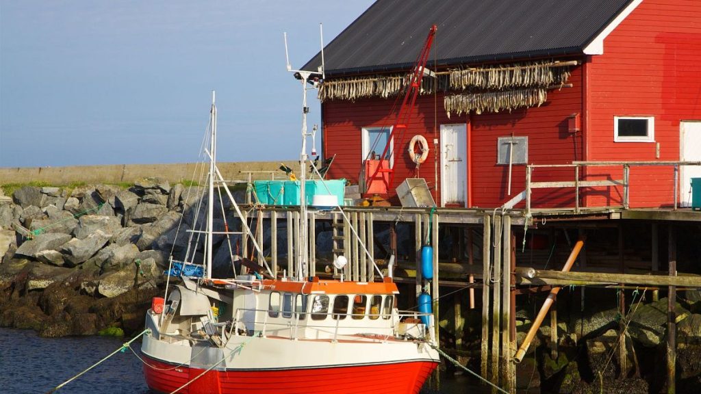 Typical Norwegian fishing boat in port with dried stock fish hanging on the front wall