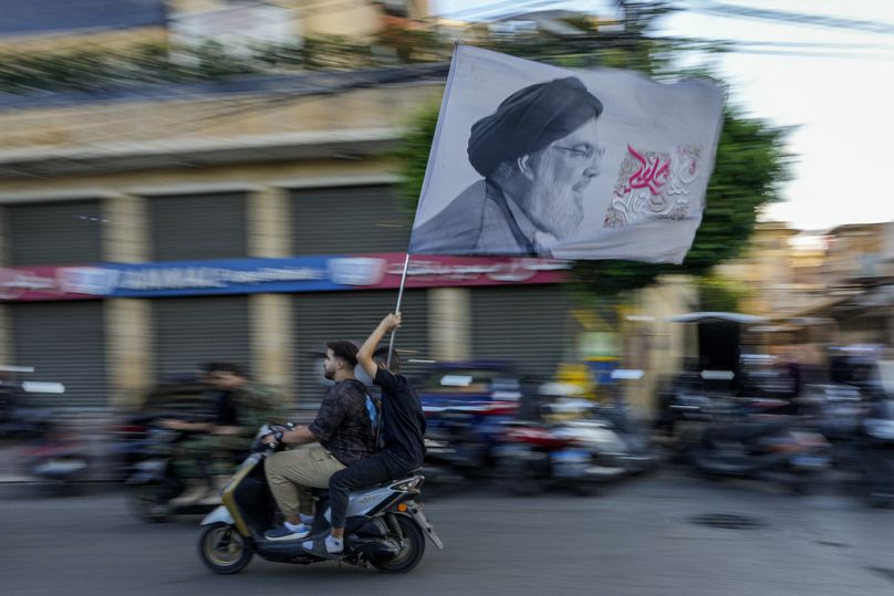 Des partisans du Hezbollah portent un drapeau représentant le chef du Hezbollah Hassan Nasrallah, le 25 septembre 2024.