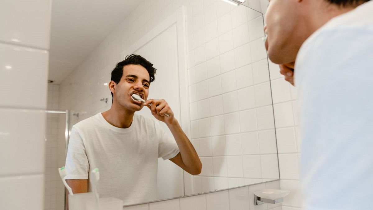 A man brushes his teeth.