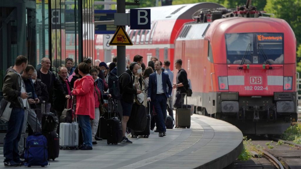 Travellers wait on a platform as a train leaves the main train station in Berlin, Germany, 1 June 2022.