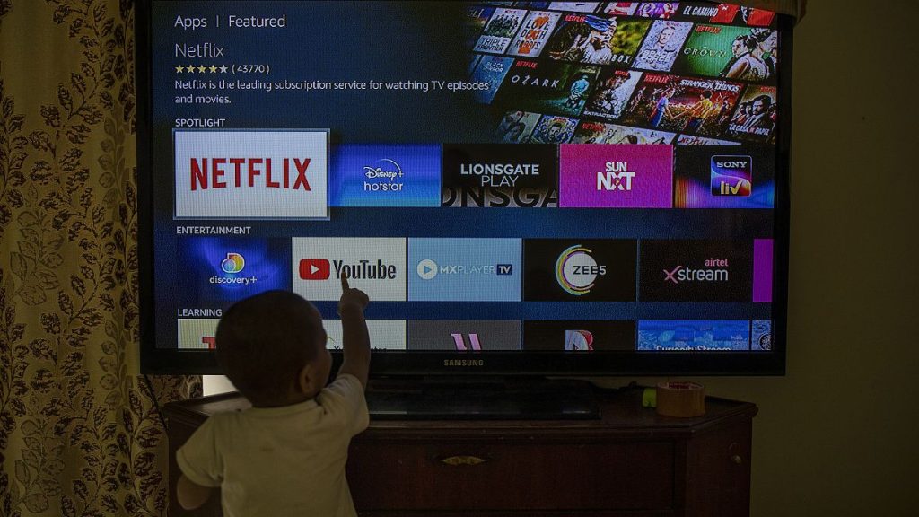 A child touches a TV screen.