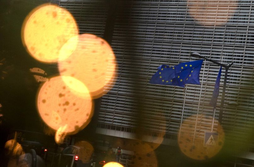 Les drapeaux de l'Union européenne flottent au vent parmi les décorations de Noël à l'extérieur du siège de l'UE à Bruxelles, en décembre 2020