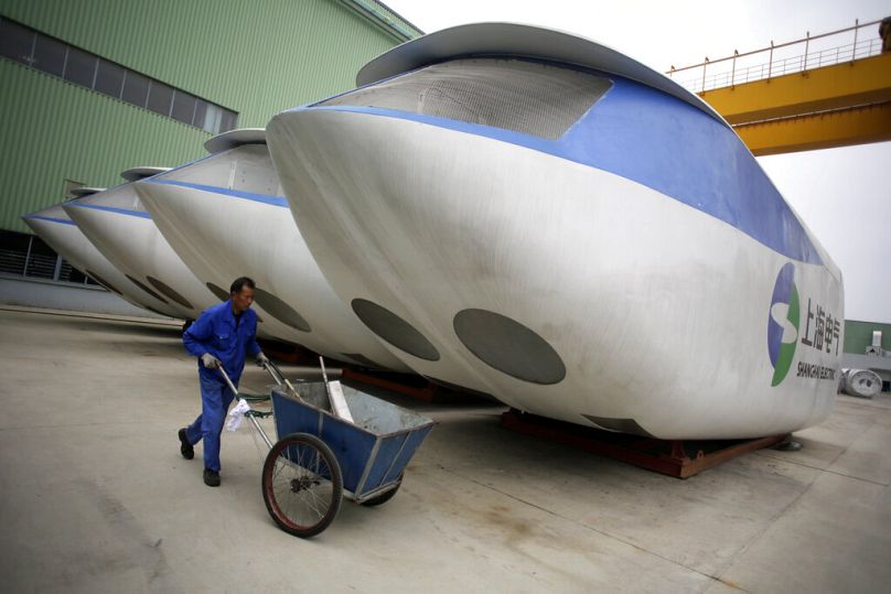 Un employé pousse le chariot de nettoyage à côté d'une éolienne à l'extérieur de l'atelier d'assemblage, avril 2012