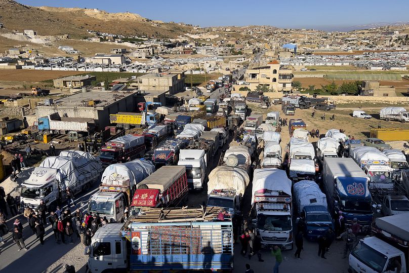 Des réfugiés syriens près de camions avec leurs biens, alors qu'ils se préparent à retourner en Syrie dans le cadre d'un retour volontaire, dans la ville frontalière libanaise d'Arsal, en mai 2024