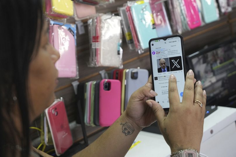 Un vendeur dans un magasin d'étuis pour téléphones portables situé à l'intérieur de la gare routière de Brasilia, août 2024