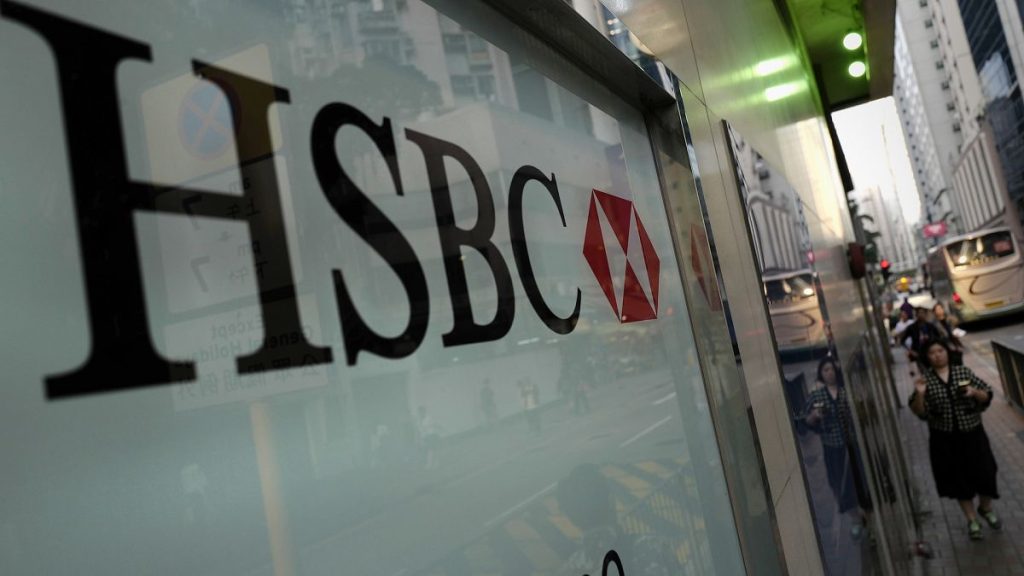 A woman walks past a branch of HSBC bank in Hong Kong