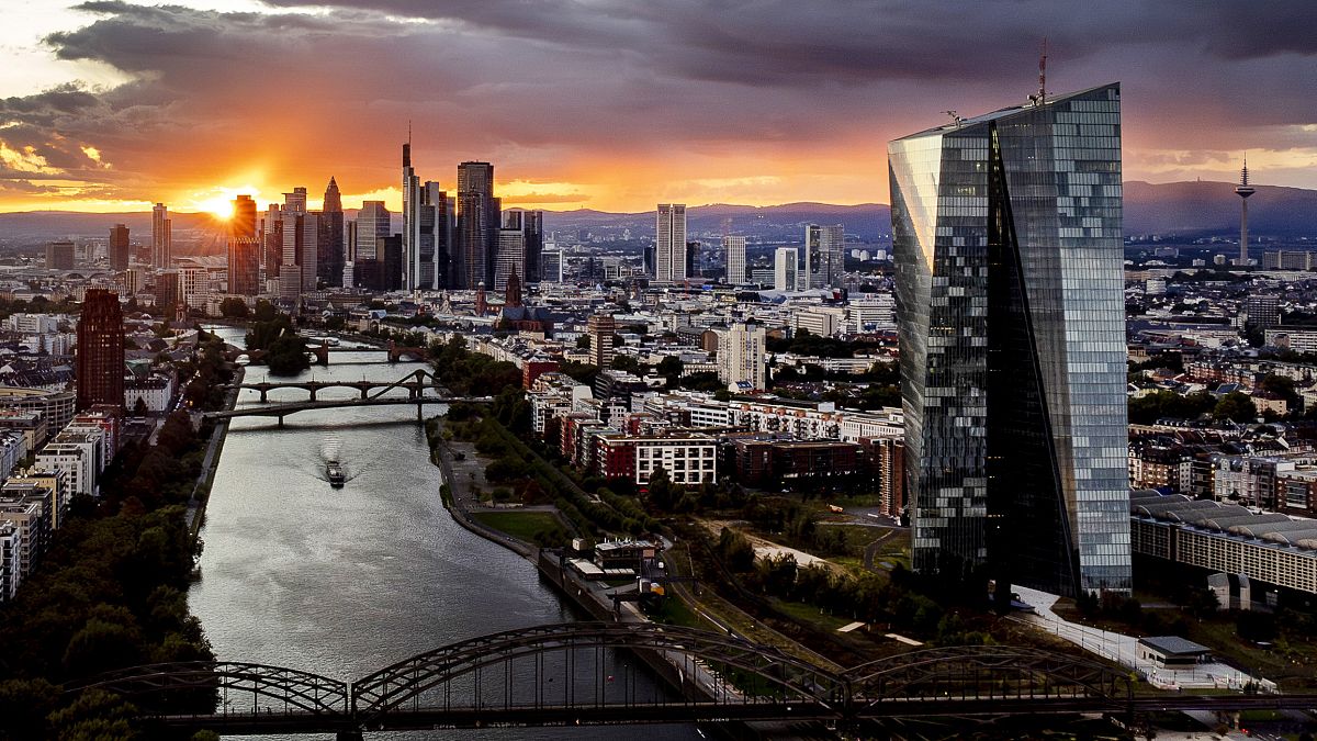 The sun sets over the buildings of the banking district, rear left, and the European Central Bank, front right, in Frankfurt, Germany, Wednesday, Sept. 11, 2024.