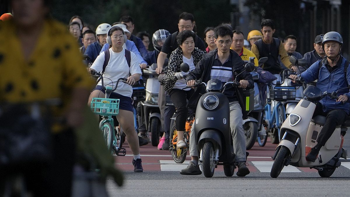 People wait at a traffic light junction during the morning rush hour in Beijing. 13 September 2024.