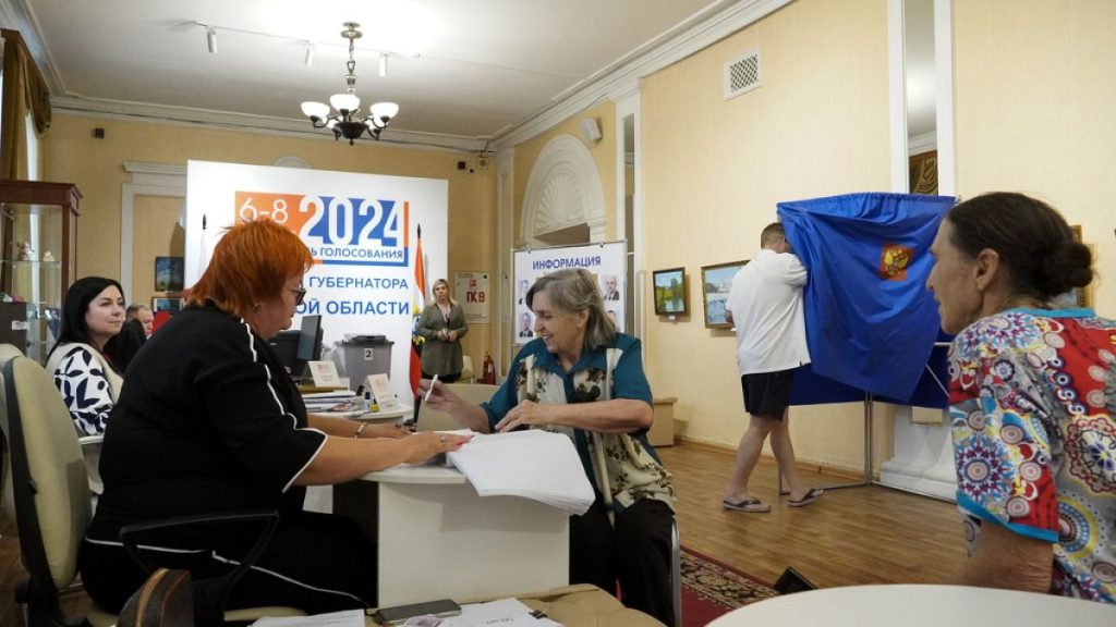 A woman receives her ballot at a polling station during the three-day Kursk region governor election, in Kursk, Russia, Sunday, Sept. 8, 2024.