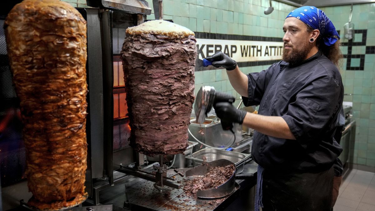 Turkish cook prepares the doner kebabs, in Berlin, Germany, Wednesday, Sept. 18, 2024.