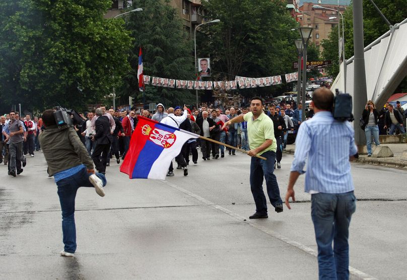 Un Serbe du Kosovo tenant un drapeau serbe tente de traverser du côté albanais de la ville depuis la partie nord de Mitrovica dominée par les Serbes, le dimanche 30 mai 2010.