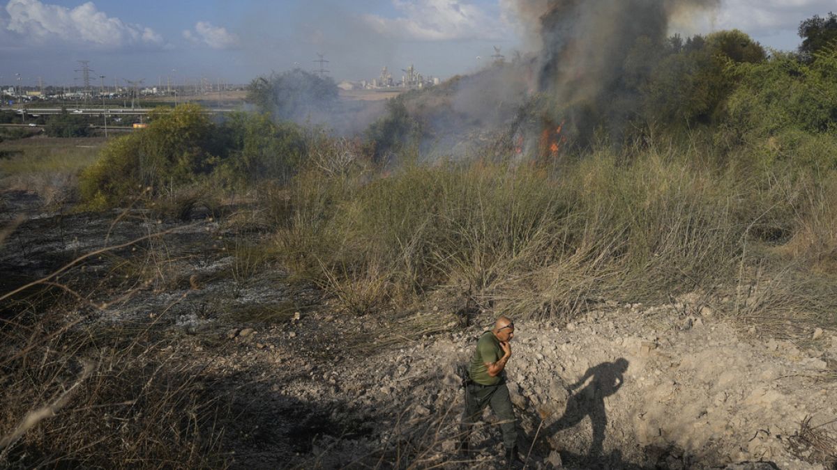 A police officer inspects a fire after the military said it fired interceptors at a missile launched from Yemen that landed in central Israel on Sunday, Sept. 15th 2024