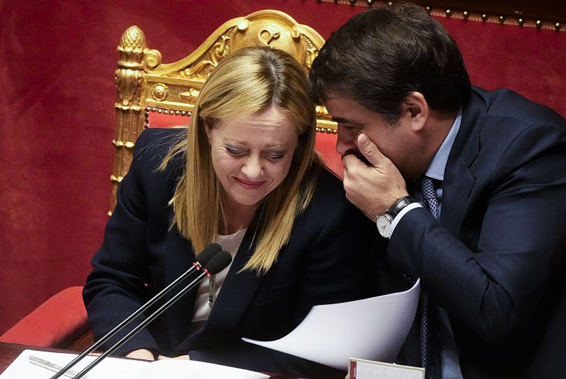 La Première ministre italienne Giorgia Meloni écoute Raffaele Fitto, ministre des Affaires européennes, après son discours au Sénat italien à Rome, le 21 mars 2023