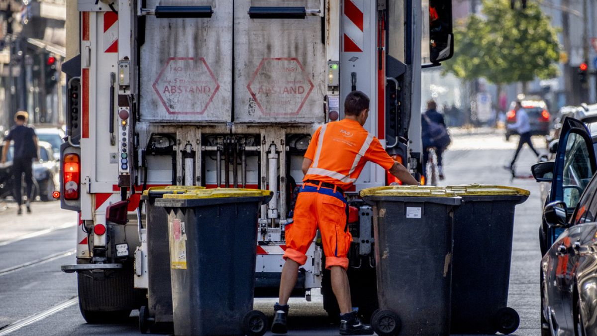 A garbage worker empties trash bins in Frankfurt, Germany, Wednesday, July 19, 2023.