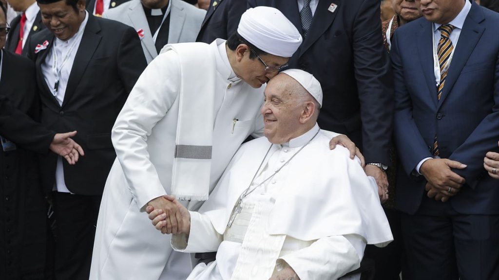 Pope Francis, right, and the Grand Imam of Istiqlal Mosque Nasaruddin Umar shakes hands during a family photo.