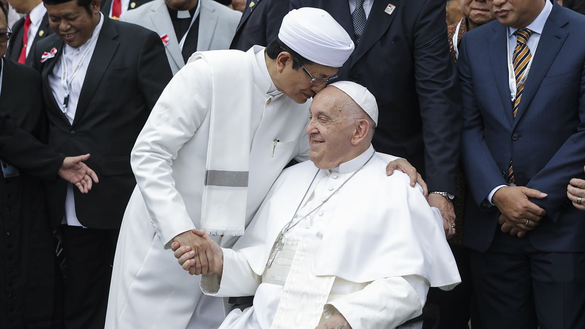 Pope Francis, right, and the Grand Imam of Istiqlal Mosque Nasaruddin Umar shakes hands during a family photo.