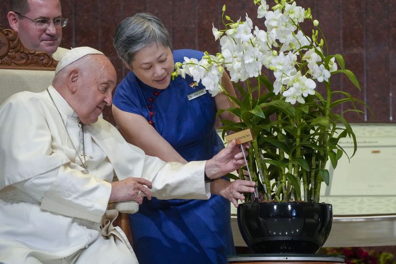 Le pape François avec un « Dendrobium Sa Sainteté le Pape François », une variété d'orchidée spécialement sélectionnée qui porte son nom, au Parlement de Singapour, le jeudi 12 septembre 2024.