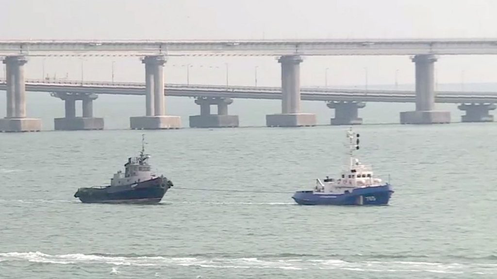 FILE: A seized Ukrainian ship, left, is towed by a Russian coast guard boat out of the port in Kerch, Crimea, with the Kerch bridge in the background, 17 November 2019