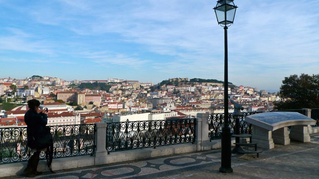 A woman takes a snapshot of the view from Sao Pedro de Alcantara Garden in Lisbon Dec. 22, 2008.