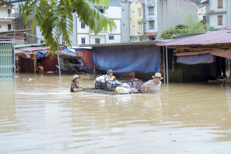 Les gens transportent leurs biens lors des inondations déclenchées par le typhon Yagi dans la province de Lang Son, au Vietnam, le lundi 9 septembre 2024. 