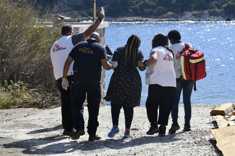 Un officier des garde-côtes aide une femme enceinte qui a survécu après qu'un bateau transportant des migrants a rencontré des problèmes au large de l'île de Samos, en Grèce, le lundi 23 septembre 2024. 