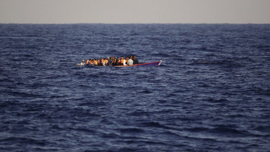 Migrants and refugees fleeing Libya on board of a wooden boat sail at the Mediterranean sea toward the Italian coasts, about 17 miles north of Sabratha, Libya, Sunday, Aug. 28