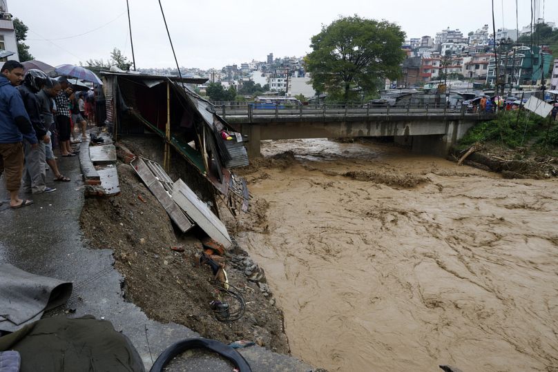 Des gens se rassemblent au bord de la rivière Bagmati en crue après de fortes pluies à Katmandou, au Népal, le samedi 28 septembre 2024.