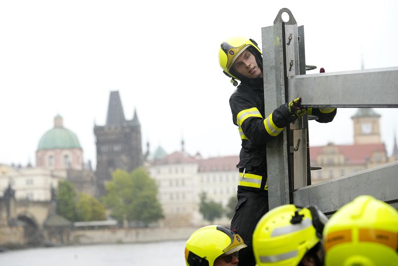 Les pompiers ajustent des parties des barrières anti-inondation à Prague, le 13 septembre 2024