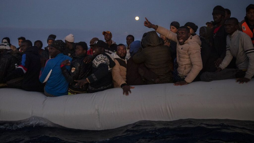 FILE - Migrants on boat in international waters, off the Libyan coast, Jan. 10, 2020