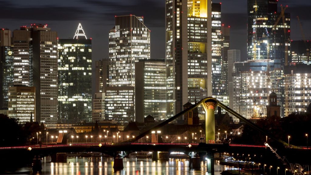 The lights of the buildings of the banking district are reflected in the river Main in Frankfurt, Germany, Monday, Oct. 31, 2022.