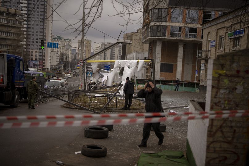 Des policiers inspectent une zone après une frappe russe apparente à Kiev, en Ukraine, le jeudi 24 février 2022. 