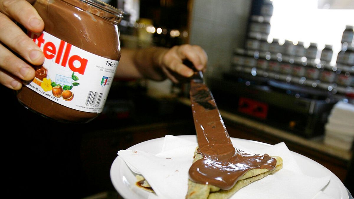 A bartender spreads Nutella on a crepe in a creperie in Rome.