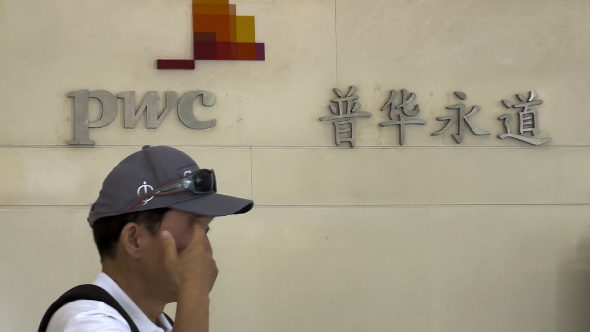 A man walks by the office of audit firm PwC, at the Fortune Financial Center in Beijing. 27 August 2024.