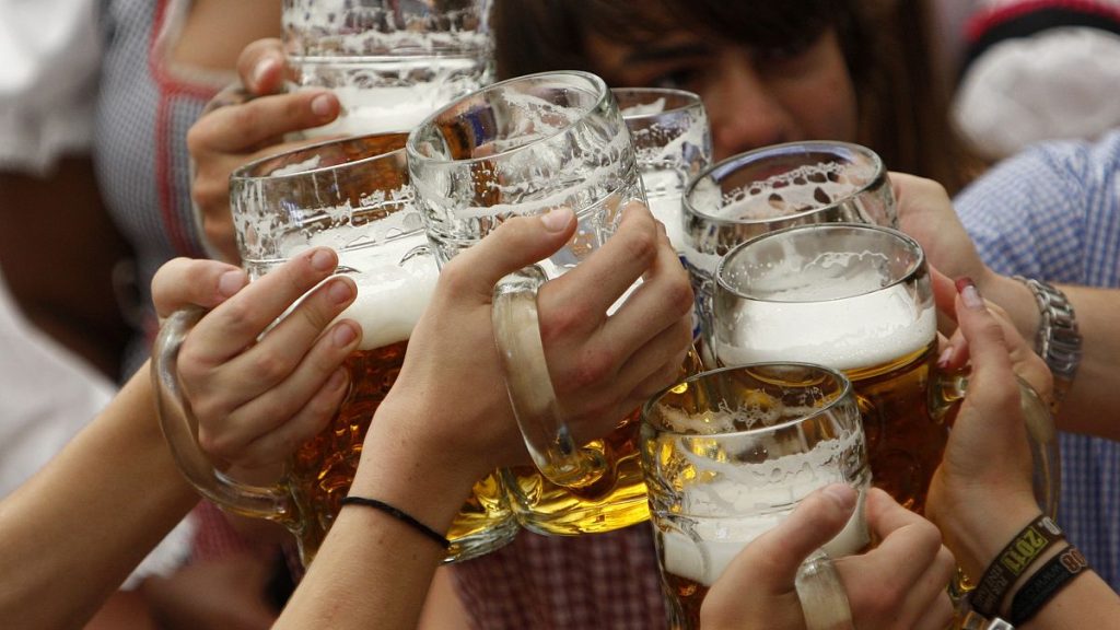 Visitors lift their beer mugs in the Hofbraeuhaus-tent after the opening of the famous Bavarian