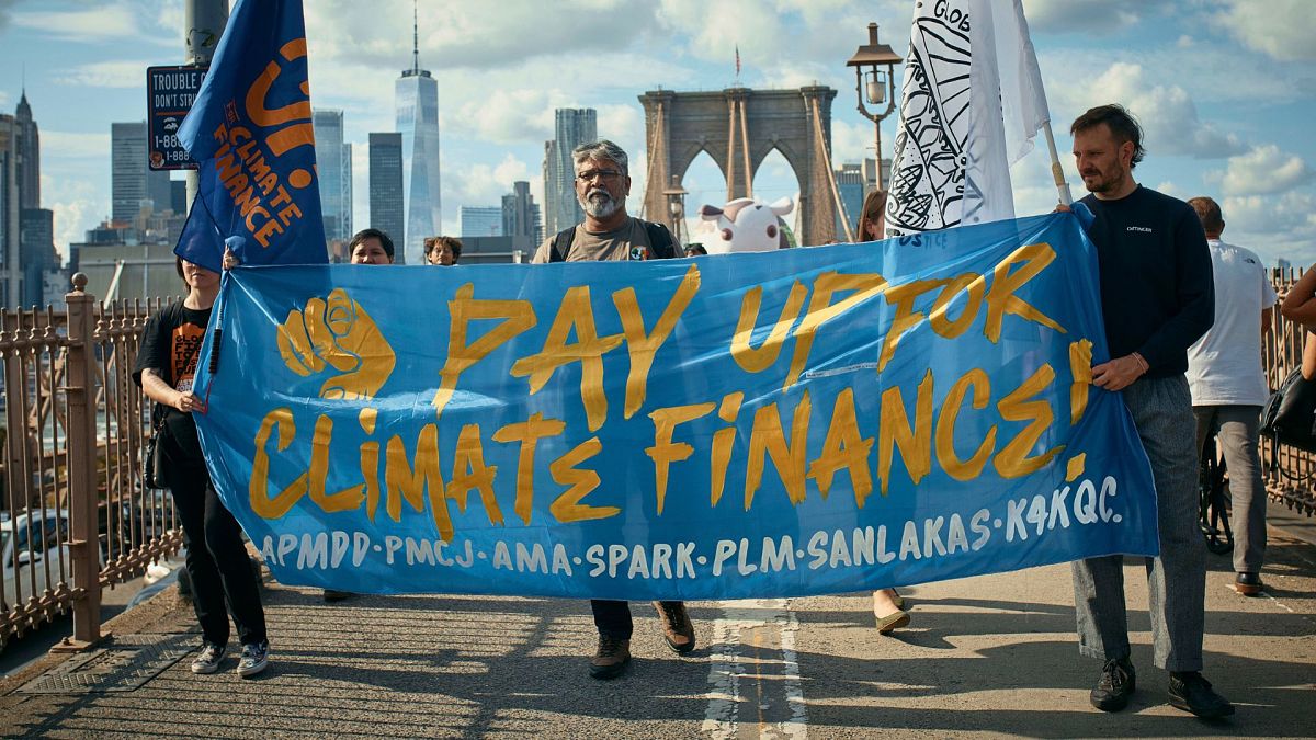 Protesters cross the Brooklyn Bridge during a Youth Climate Strike march to demand an end to the era of fossil fuels, 20 September 2024, in New York.