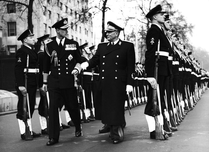 Accompagné du duc d'Édimbourg, à gauche, portant l'uniforme d'amiral, Josip Broz Tito inspecte la garde d'honneur navale à son arrivée à Westminster, Londres, le 15 mars 1953