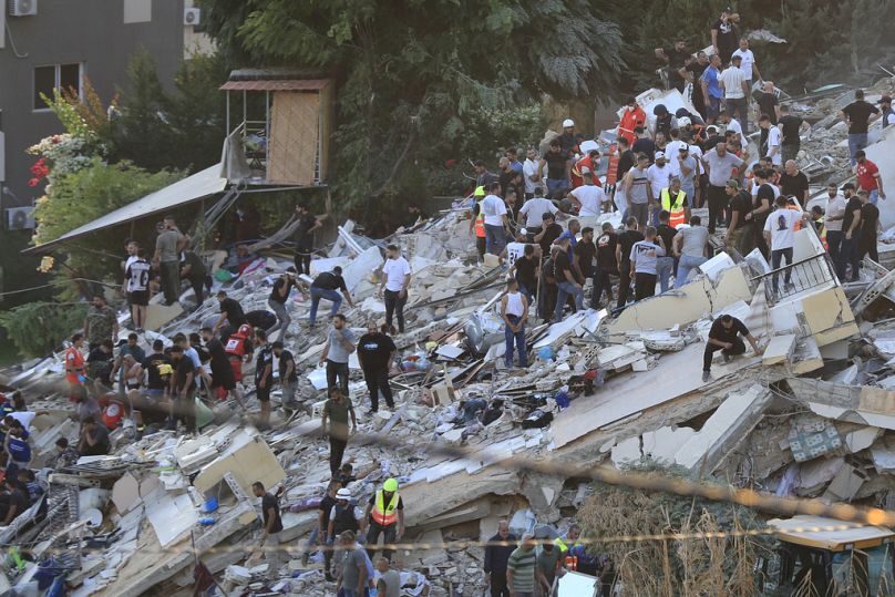 Des personnes et des secouristes dans le quartier d'Ain el-Delb, à l'est de la ville portuaire de Sidon, au Liban, le dimanche 29 septembre 2024.