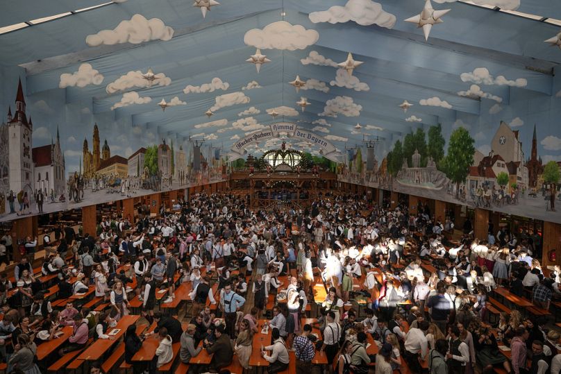 Les visiteurs attendent sous la tente de la brasserie Hacker-Pschorr le début du 189e festival de la bière « Oktoberfest » à Munich, en Allemagne, le samedi 21 septembre 2024.