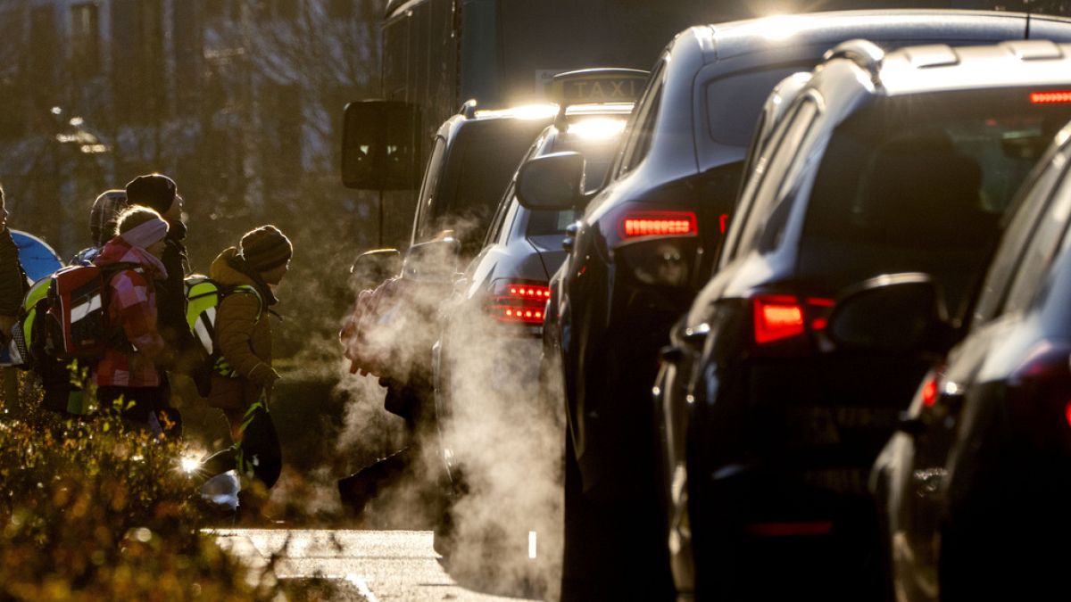 Cars release exhaust fumes as children head to school in Frankfurt, Germany