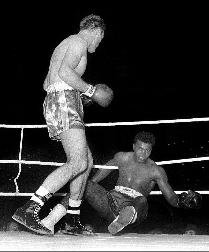 Muhammad Ali, renversé par Henry Cooper lors de leur match de boxe à Wembley, Londres.