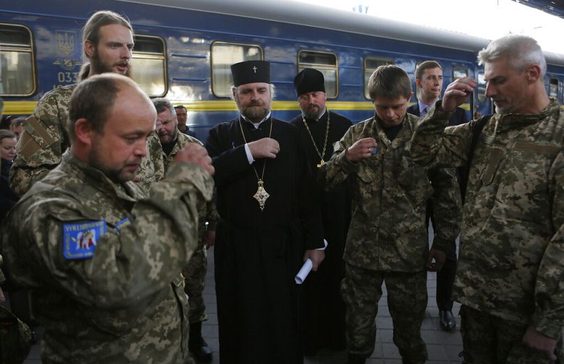 Ukrainian orthodox chaplains of Ukrainian Armed Forces pray as they prepare to leave Kiev 