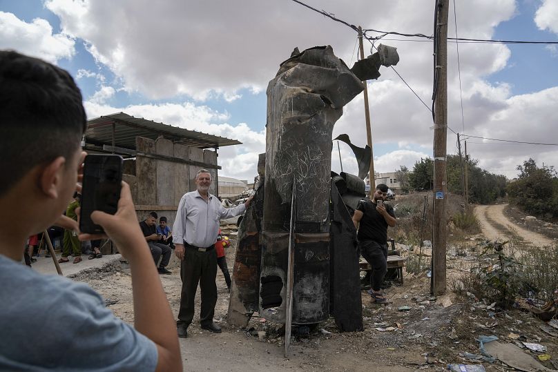 Des Palestiniens se prennent en photo avec les débris d'un missile iranien intercepté par Israël, dans la ville d'Hébron, en Cisjordanie, le 2 octobre 2024.