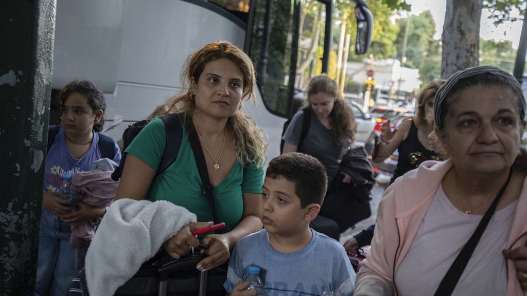 Greek citizens, who were evacuated from Lebanon with a Greek military transport aircraft stand outside the Greek Foreign ministry building in Athens, October 3, 2024