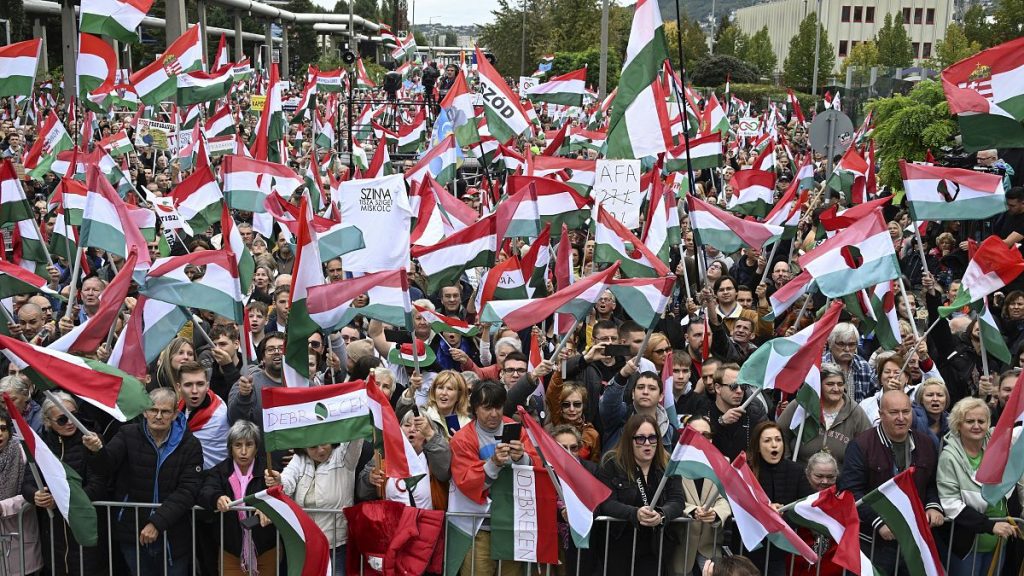 Participants wave national flags during a demonstration against public media at the MTVA headquarters in Budapest, October 5, 2024