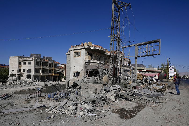 Un journaliste documente les bâtiments endommagés sur le site d'une frappe aérienne israélienne dans le village libanais de Temnin, le 5 octobre 2024.