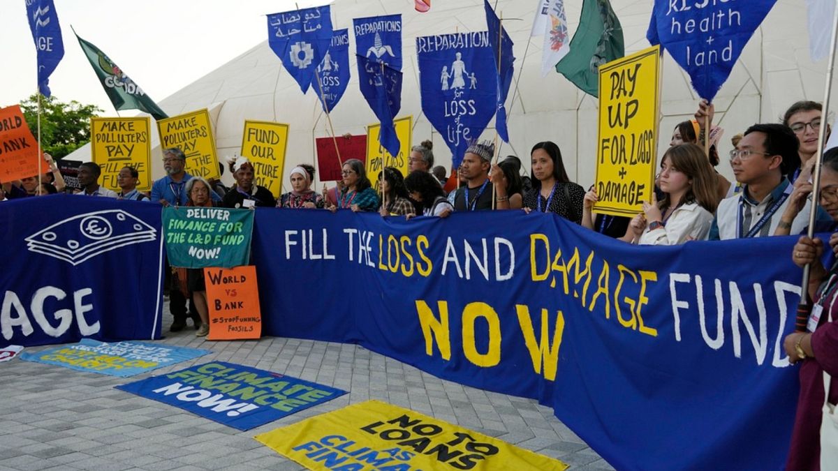 Activists demonstrate with a sign that reads