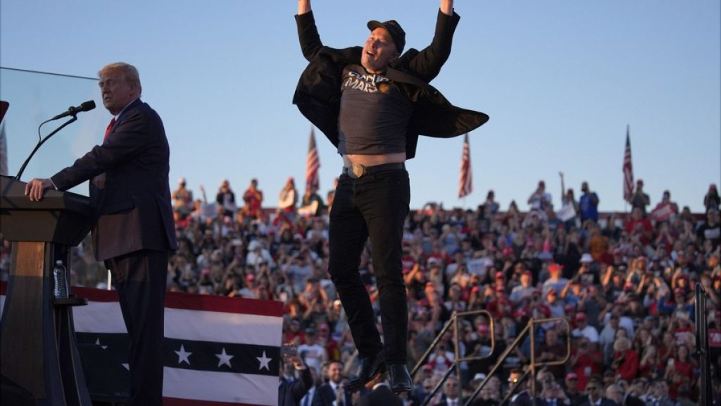 Elon Musk jumps on the stage as Republican presidential nominee Donald Trump speaks at a campaign rally at the Butler Farm Show, USA Saturday, Oct. 5, 2024,