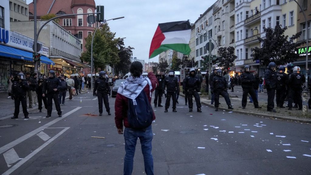 A protestor waves the Palestinian flag during a pro-Palestinian rally in Berlin, Germany, Sunday, Oct. 6, 2024.